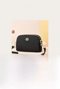 Détail du sac bandoulière matelassé noir avec doubles fermetures éclair et logo doré chic