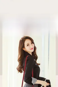 Détail d'une chemise noire chic avec poignets rayés et un sac à bandoulière rouge