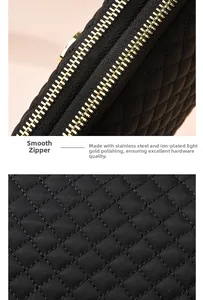 Détail de la fermeture éclair dorée et des coutures du tissu matelassé du sac bandoulière