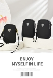 Close-up of three black nylon crossbody phone bags with triple zippers on geometric stands