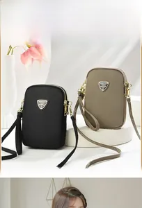 Detail of khaki and black nylon mini crossbody bags with gold triangle logo hardware