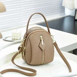 Brown faux leather crossbody round bag with multiple zippers and adjustable strap