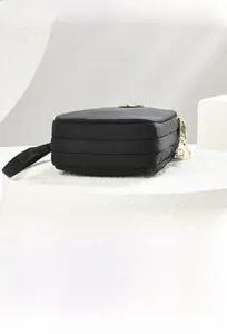 Top view of black multi-layered crossbody bag with gold zippers on a white display stand