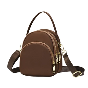 Brown mini nylon backpack with three-layer gold zippers and adjustable crossbody strap