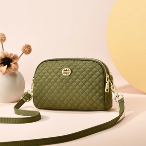 Sac bandoulière matelassé vert foncé avec logo doré et double fermeture éclair chic