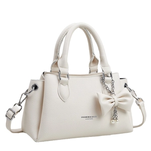 Fashionable beige lychee leather handbag with pearl bow charm and shoulder strap