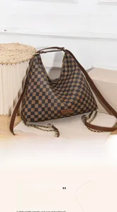 Detailed view of brown checkered pattern faux leather surface with gold chain strap