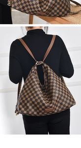 Detail of checkered brown underarm bag with gold chain and leather shoulder strap