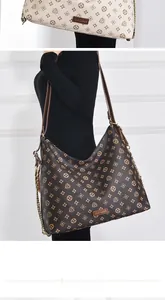 Detail of vintage monogram shoulder bag with dual chain straps and metal logo plate