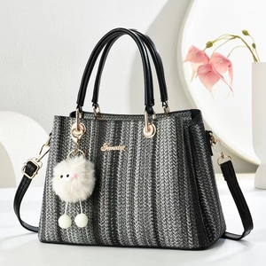 Striped woven tote bag with black leather handles and cute plush charm for daily commute