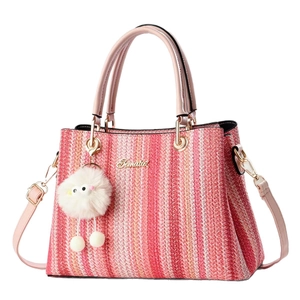 Pink and red woven tote bag with adjustable shoulder strap and fuzzy pompom charm