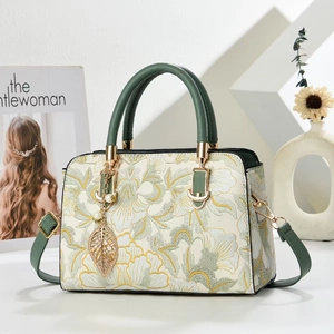 Sac à main broderie florale vintage avec poignées vertes et perles sur fond blanc