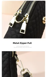 Close-up of premium gold zippers and hardware on black quilted oxford fabric bag