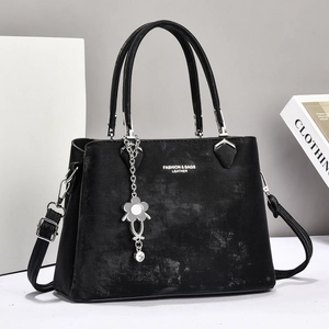 Minimalist black PU leather shoulder bag with vintage texture and floral pendant charm