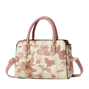 Sac à main brodé de fleurs avec lanières en cuir rose et pendentif feuille de perle