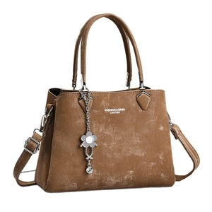 Brown vintage leather tote bag with top handles and adjustable shoulder strap on white base