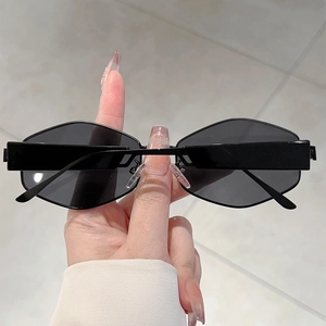 Détail de lunettes de soleil géométriques noires Y2K avec des branches larges modernes