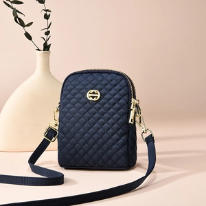 Navy blue quilted nylon crossbody bag with gold hardware and adjustable shoulder strap