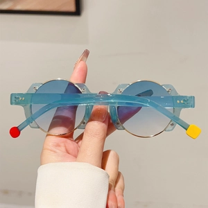 Detail of round sunglasses with blue gradient lenses and colorful geometric temple tips