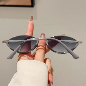 Detail of silver metal frame sunglasses with dark grey oval lenses and soft temple tips
