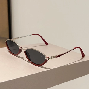 Detail of vintage cat-eye sunglasses with burgundy frames and silver metal accents