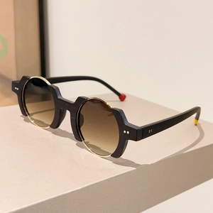 Detail of round frame sunglasses with gold studs and brown gradient lenses
