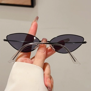 Détail de lunettes de soleil œil de chat fines en métal noir avec verres gris