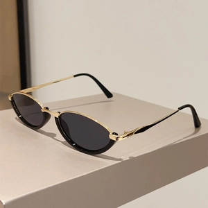 Detail view of retro cat-eye sunglasses with gold metal frame and black lenses