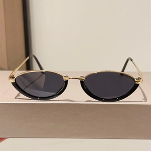 Detail view of vintage cat-eye sunglasses with gold metal and black frames on display