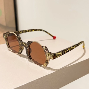 Detail of round leopard print sunglasses with contrasting red and yellow temple tips