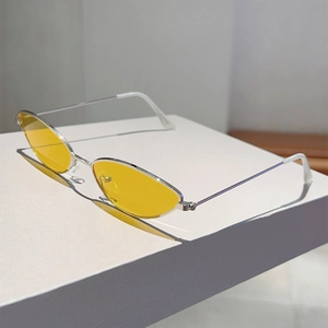 Détail de lunettes de soleil œil-de-chat vintage avec verres jaunes et monture argent