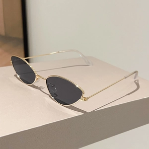 Vue détaillée de lunettes œil de chat avec monture en métal doré sur socle beige