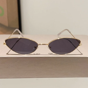 Détail de lunettes de soleil œil-de-chat avec monture en métal doré et verres foncés