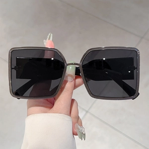Detail of square metal sunglasses with textured dark grey frame and black lenses