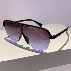 Détail de lunettes Y2K avec verres dégradés violet-bleu et monture supérieure noire