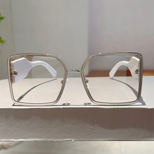 Close-up of silver metal frame with engraved texture and wide white temples on glasses