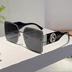 Detail of square sunglasses with metal trim and circular S logo on thick black temples