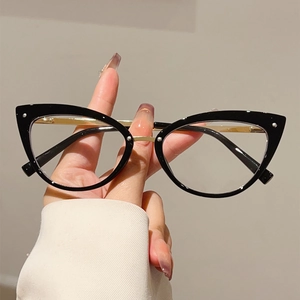 Gros plan d'une monture de lunettes œil-de-chat noire avec pont et branches dorés
