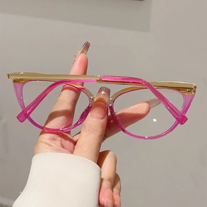 Détail de lunettes œil-de-chat roses avec branches et pont en métal doré