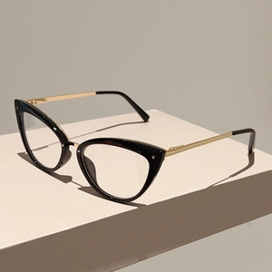 Détail de lunettes œil-de-chat avec monture noire et branches en métal doré