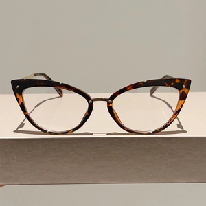 Détail de lunettes œil-de-chat avec motif écaille foncée et branches en métal doré