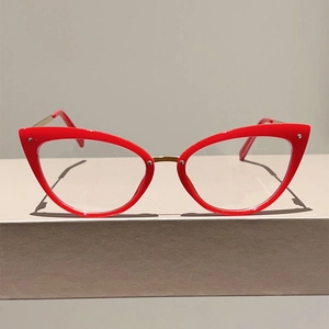 Détail de lunettes œil-de-chat vintage avec monture rouge et branches dorées