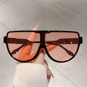 Close-up of oversized shield sunglasses featuring a glossy black frame and silver accents