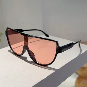 Detail of oversized shield sunglasses with black frame and light pink translucent lenses