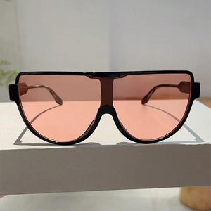 Detail of trendy shield sunglasses with black oversized frame and pink orange lenses