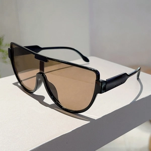 Detail of oversized shield sunglasses with glossy black frame and brown tinted lenses