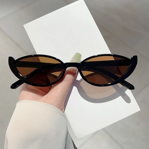 Detail of narrow cat-eye sunglasses with glossy black frames and dark brown lenses