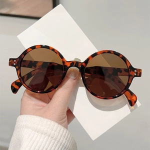 Retro round tortoise shell sunglasses with dark brown lenses and silver rivet accents