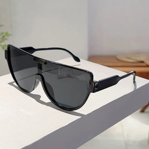 Detail view of oversized black shield sunglasses on a modern geometric display stand