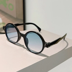 Detailed shot of retro round sunglasses with silver rivets and blue gradient lenses